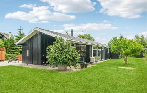 a black house with a green yard at Awesome Home In Ebeltoft With Sauna in Ebeltoft