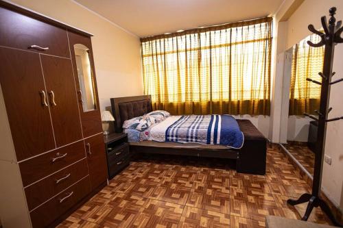 une chambre avec un lit, une commode et une fenêtre dans l'établissement Depawanka 3 Departamento amoblado y equipada, à Huancayo