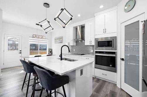 a white kitchen with a sink and a counter at The Happy place - Luxurious, Cozy and Modern Home with Air-condition, Netflix, Free Parking close to Airport and West Edmonton Mall in Edmonton