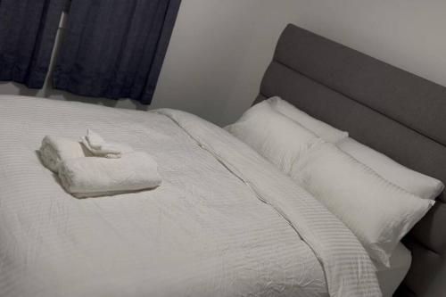 a white bed with two towels and pillows on it at The Happy place - Luxurious, Cozy and Modern Home with Air-condition, Netflix, Free Parking close to Airport and West Edmonton Mall in Edmonton