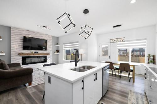 a white kitchen with a sink and a living room at The Happy place - Luxurious, Cozy and Modern Home with Air-condition, Netflix, Free Parking close to Airport and West Edmonton Mall in Edmonton