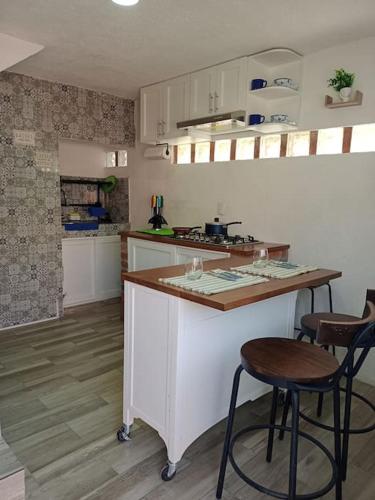 a kitchen with two bar stools and a counter top at Casita azul in Morelia