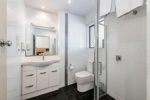 a bathroom with a toilet and a sink and a shower at Bundaberg International in Bundaberg