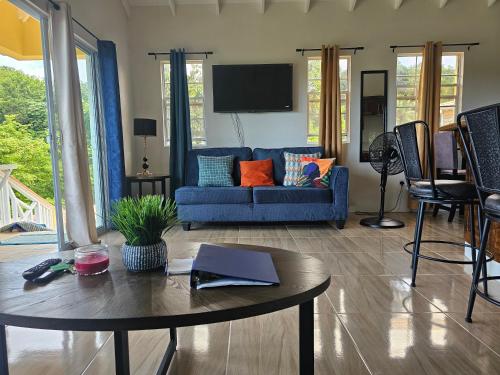 a living room with a blue couch and a table at Royal Escape - 2 in Anse La Raye