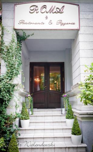 una entrada a un edificio con una puerta con plantas en Hotel Roma, en Kalisz