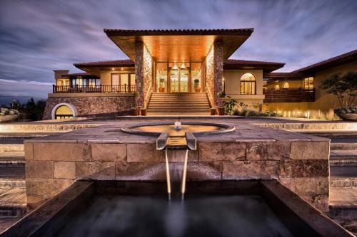 a home with a fountain in front of a building at Grace Cafayate in Cafayate