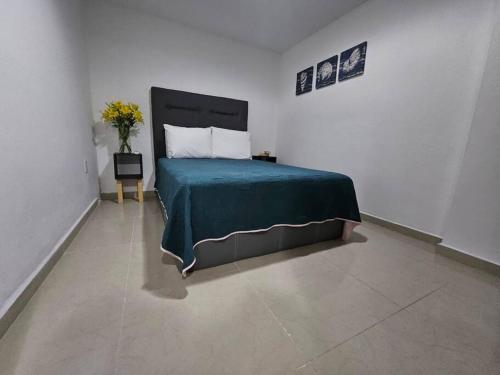 ein Schlafzimmer mit einem Bett in einem weißen Raum in der Unterkunft Hermoso Apartamento 2 recámaras L4 in Puerto Vallarta