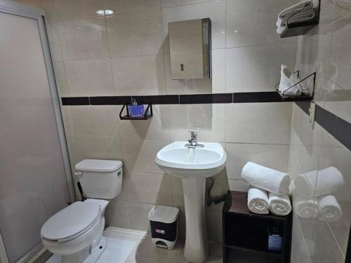 ein Badezimmer mit weißer Toilette und Waschbecken in der Unterkunft Hermoso Apartamento 2 recámaras L4 in Puerto Vallarta