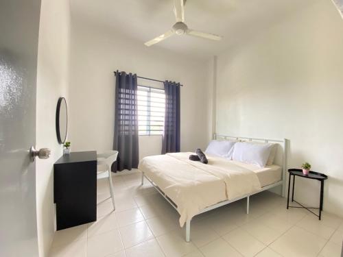 a bedroom with a bed and a desk and a window at Sutra Impian Seaview Sutra Villa 2 in Kuantan