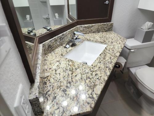 a bathroom with a sink and a toilet at Quality Inn & Suites Denver International Airport in Denver