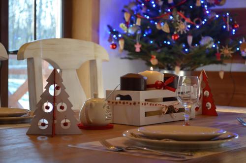 a table with a christmas table setting with a christmas tree at Zagroda Krasna in Polańczyk