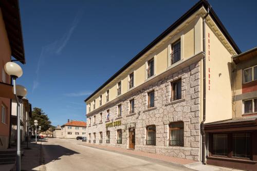 a stone building on the side of a street at Hotel Knez in Kupres