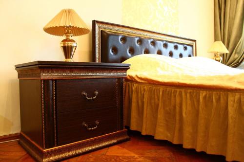 a bedroom with a bed and a lamp at Ratusha Apartments in Lviv