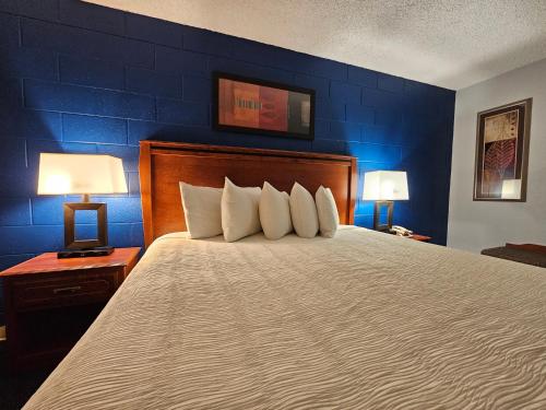 a bedroom with a large bed with two lamps at 1st Choice Inn of Rawlins in Rawlins