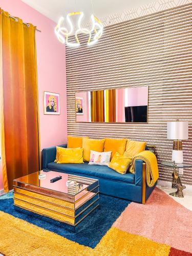 a living room with a blue couch with yellow pillows at Dolly's Art Deco - Luxe Stay Near Broadway in Nashville