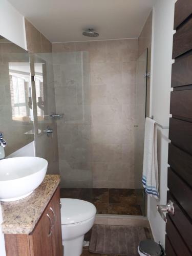 a bathroom with a sink and a toilet and a shower at Laureles Penthouse rooftop Suite in Medellín