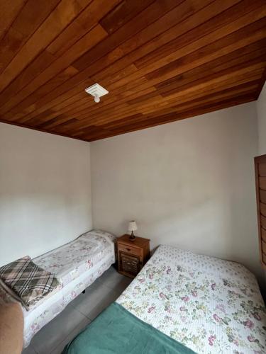 a bedroom with two beds and a wooden ceiling at Casa Almeida in Tiradentes
