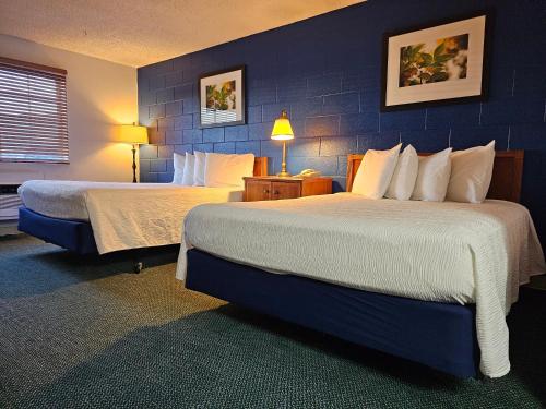 a hotel room with two beds and a blue wall at 1st Choice Inn of Rawlins in Rawlins