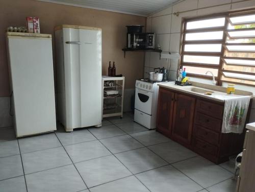 une cuisine avec deux réfrigérateurs et un évier dans l'établissement Casa sonho de verão, à Tramandaí