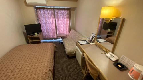 a hotel room with a bed and a mirror at ryugasakiplazahotel honkan in Ryūgasaki