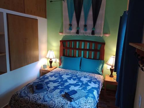 a bedroom with a blue bed with two lamps at Manzanillo BNB in Manzanillo