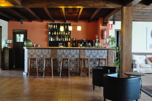 a bar in a restaurant with chairs around it at Hotel Rural La Paloma in Villanueva de Tapia