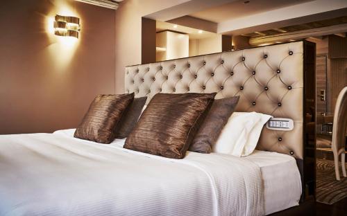 a bedroom with a large bed with brown pillows at LE RÊVE DE NAIM Roma in Rome