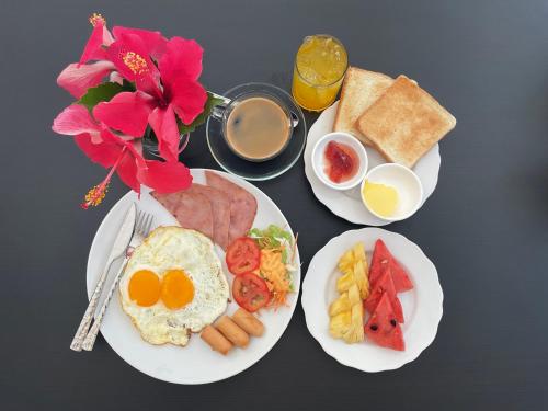 two white plates of breakfast food with eggs and toast at honeyhome kohkood in Ko Kood