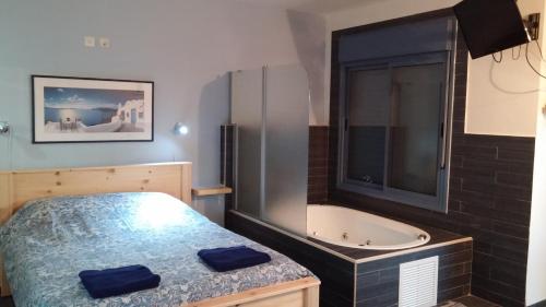 um quarto com uma cama e uma banheira em Greek Relaxation em Ma‘yan Barukh