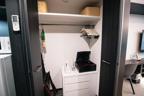 a room with a closet with a desk and a shelf at GOLD STAY Nagoya Sakae ゴールドステイ名古屋栄 in Nagoya