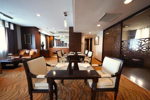 a restaurant with tables and chairs in a room at Saigon Prince Hotel in Ho Chi Minh City