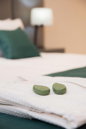 two green coins sitting on top of a bed at Hotel Boutique Gualamba in General Pinedo