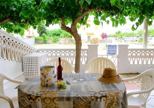 a table with a bottle of wine and a hat on it at Euromar II - TEPINSA Alquiler de Apartamentos in Torreblanca
