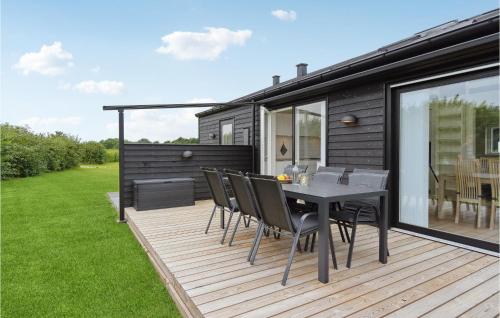 a deck with a table and chairs on a house at Nice Home In Frørup With Kitchen in Tårup