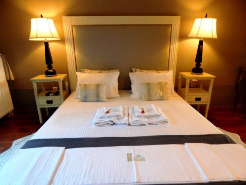 a bedroom with a bed with two towels on it at Villa Vravrona Tower & Suites in Markopoulo