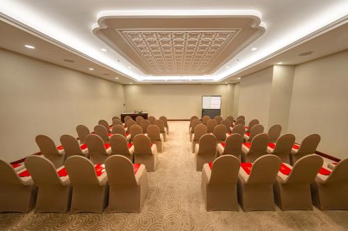 a conference room with chairs and a screen in it at Saigon Prince Hotel in Ho Chi Minh City