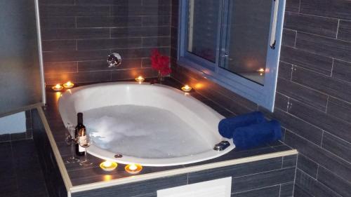 uma casa de banho com uma banheira com luzes à volta em Greek Relaxation em Ma‘yan Barukh