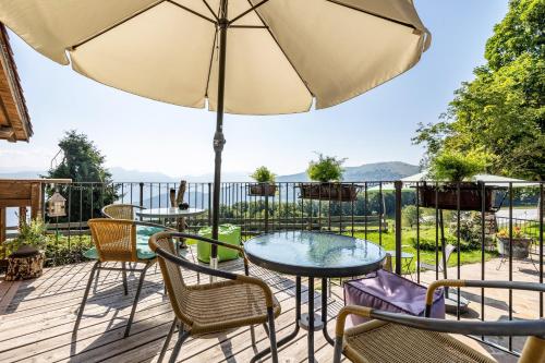 a patio with a table and chairs and an umbrella at Agritur El Casel in Brentonico