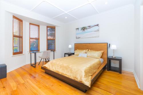 a bedroom with a bed and a desk at Glenelg House Modern 5QBed,1cot,3Bth, 4TV,FastWIFI in Glenelg