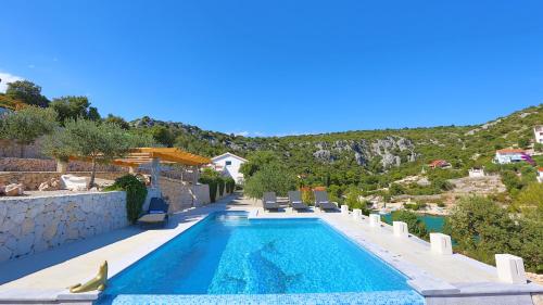 a swimming pool with a mountain in the background at Villa Hera Sevid in Sevid