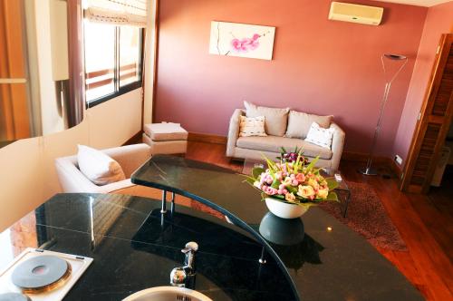 a living room with a vase of flowers on a glass table at Palissandre ANTANANARIVO in Antananarivo