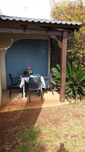 a patio with a table and chairs under a pergola at Greek Relaxation in Ma‘yan Barukh