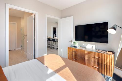 a bedroom with a bed and a flat screen tv at Luxury Furnished Apartments by Hyatus Downtown at Yale in New Haven