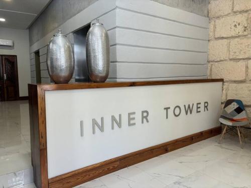 two vases sitting on top of a sign in a lobby at Espectacular depa en el Barrio in Monterrey