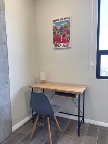 a desk with a blue chair next to a wall at Espectacular depa en el Barrio in Monterrey