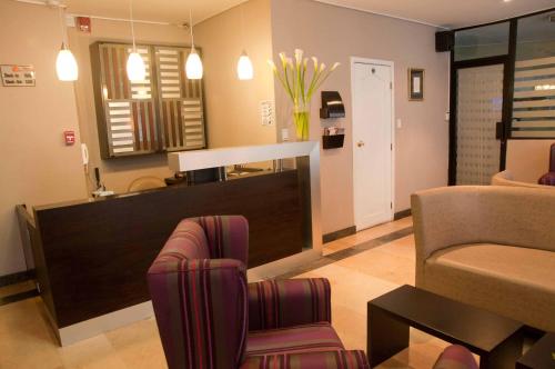a living room with a couch and a chair at Walther Suites in Quito
