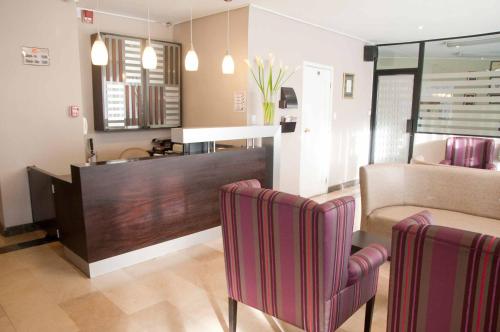 a living room with two chairs and a couch at Walther Suites in Quito