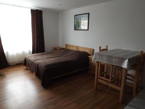 ein Schlafzimmer mit einem Bett und einem Tisch darin in der Unterkunft Ferienwohnung Gittersee in Dresden