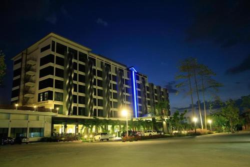 a building with a blue light on the side of it at Alvarez Hotel in Buriram