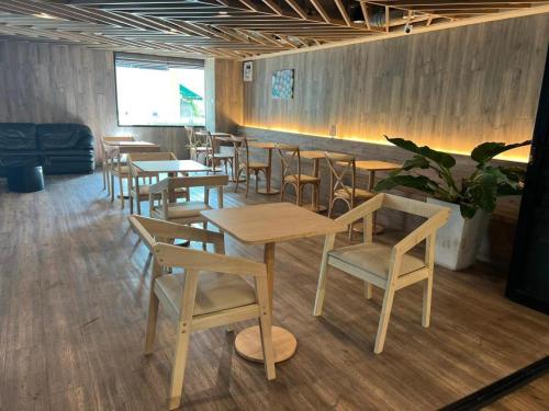 a restaurant with wooden tables and chairs in a room at Wsotel Hotel in Songkhla